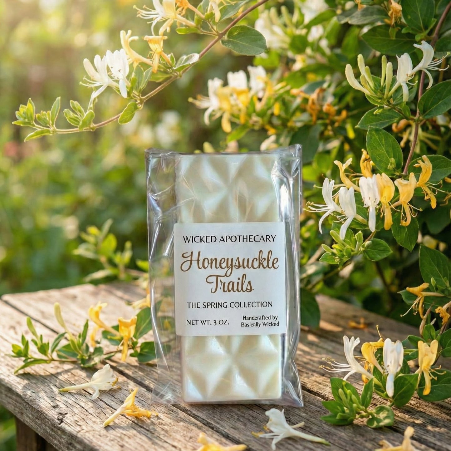 Wicked Apothecary Honeysuckle Trails packaging on a wooden surface with honeysuckle flowers in the background