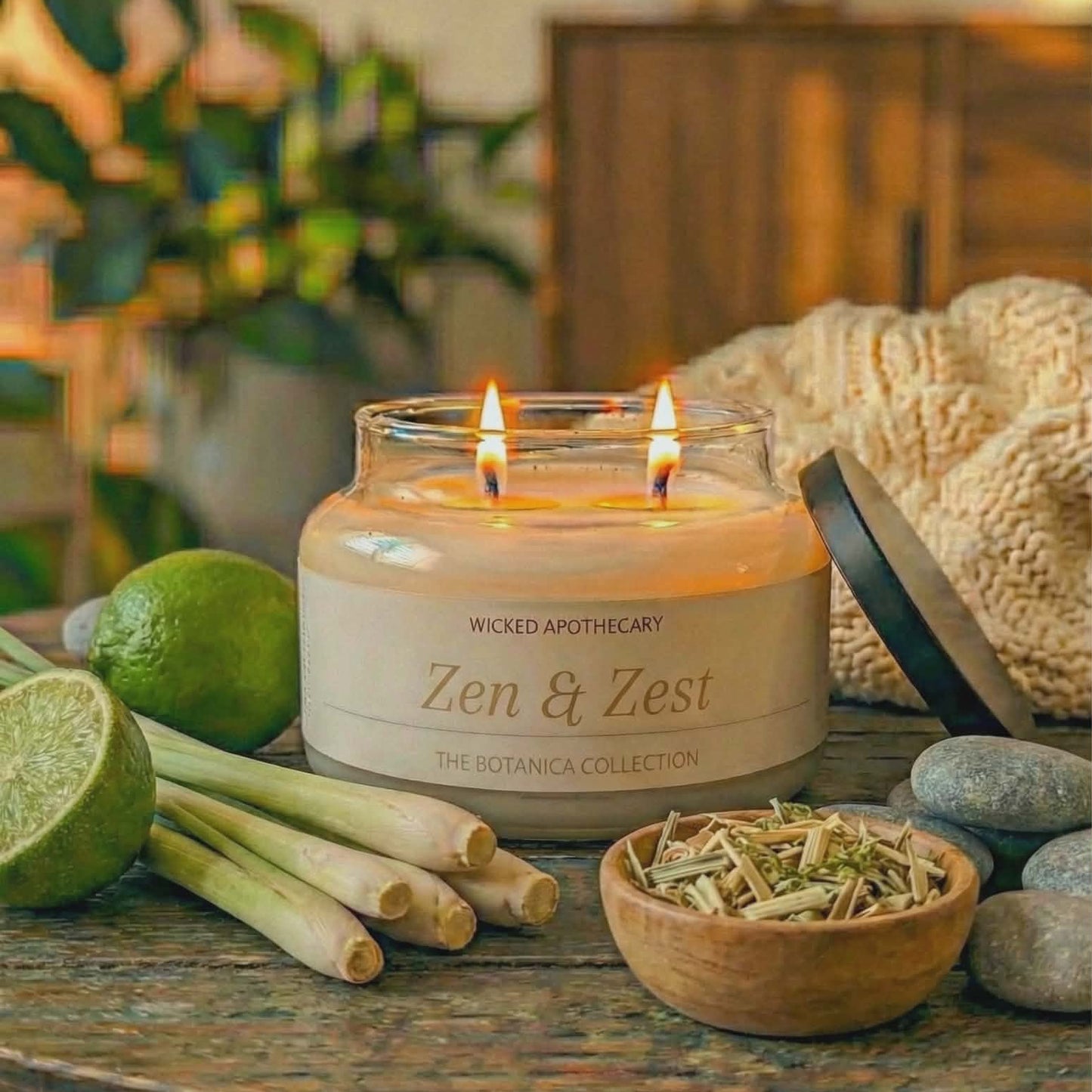 Candle labeled 'Zen & Zest' on a table with limes, lemongrass, and stones.