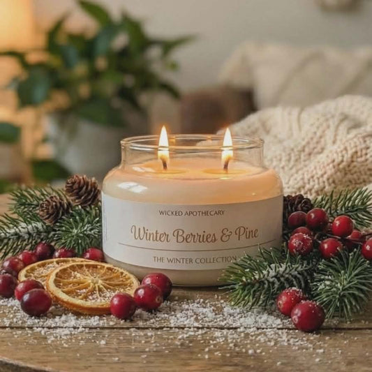 Candle labeled 'Winter Berries & Pine' on a table with decorative elements.