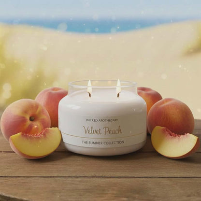 Wicked Apothecary Velvet Peach candle with peaches on a wooden surface