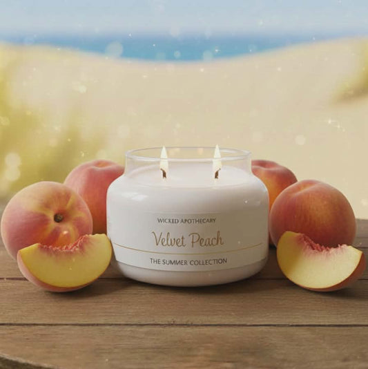 Wicked Apothecary Velvet Peach candle with peaches on a wooden surface