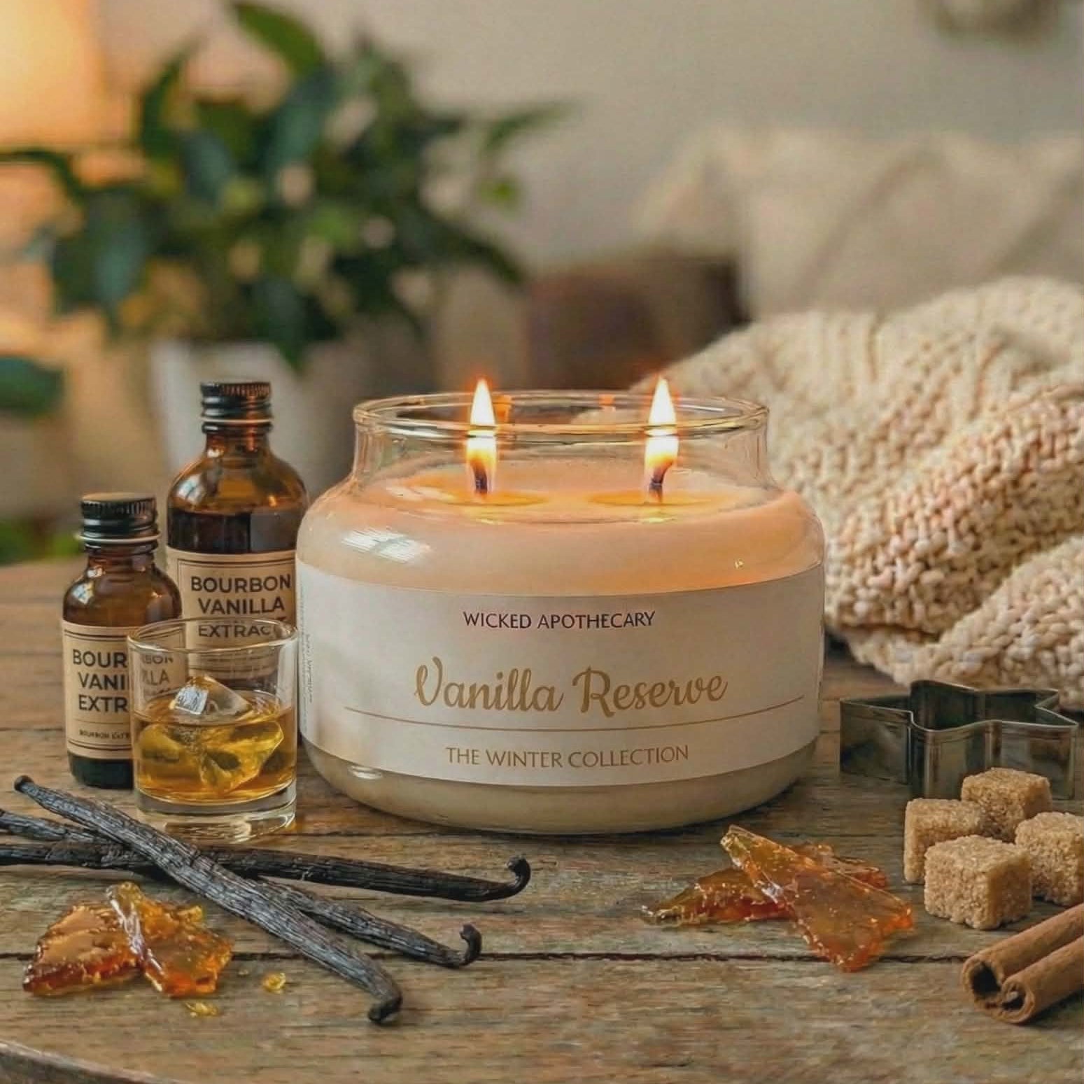 Vanilla Reserve candle on a wooden table with vanilla beans and bottles in a cozy setting.