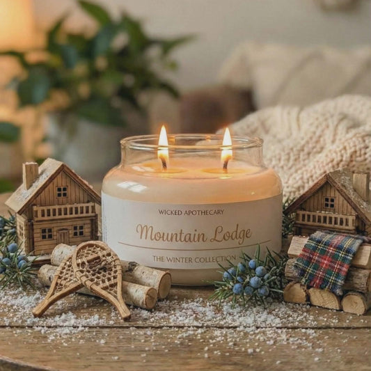 Candle in a jar labeled 'Mountain Lodge' on a wooden surface with decorative elements.