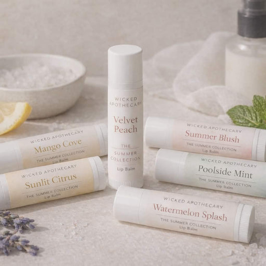 Collection of Wicked Apothecary lip balms on a textured surface with a lemon and lavender.