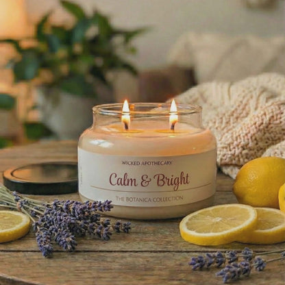 Candle labeled 'Calm & Bright' on a wooden table with lemons and lavender.