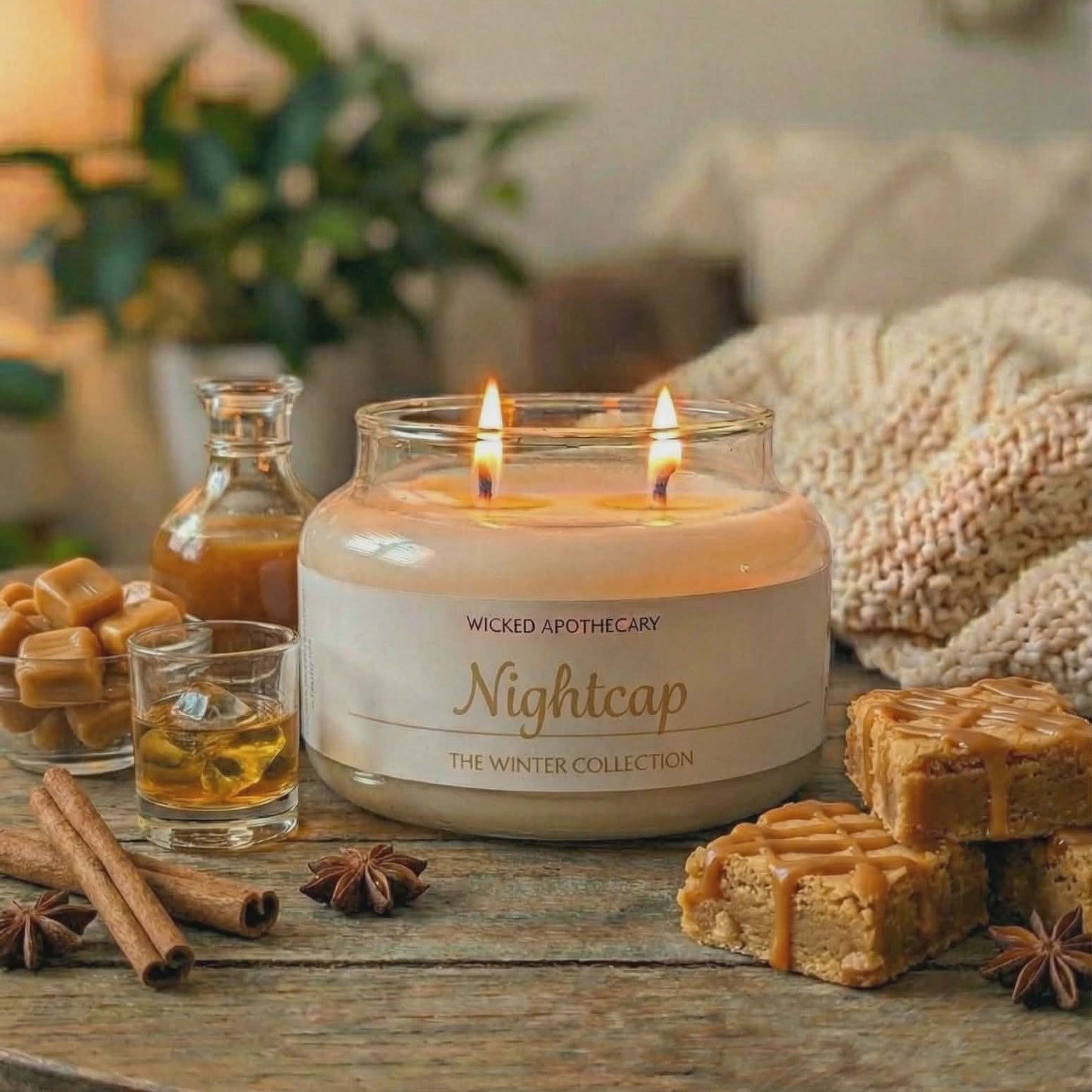 Wicked Apothecary 'Nightcap' candle on a wooden table with waffles, syrup, and cinnamon sticks.