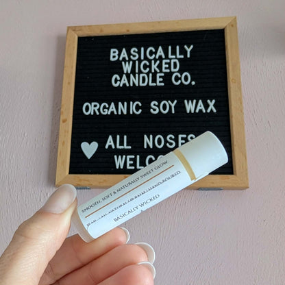 Hand holding a product with a letterboard displaying 'Basically Wicked Candle Co.'