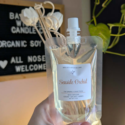 Hand holding a clear bag with a label, likely containing a product, against a blurred background.