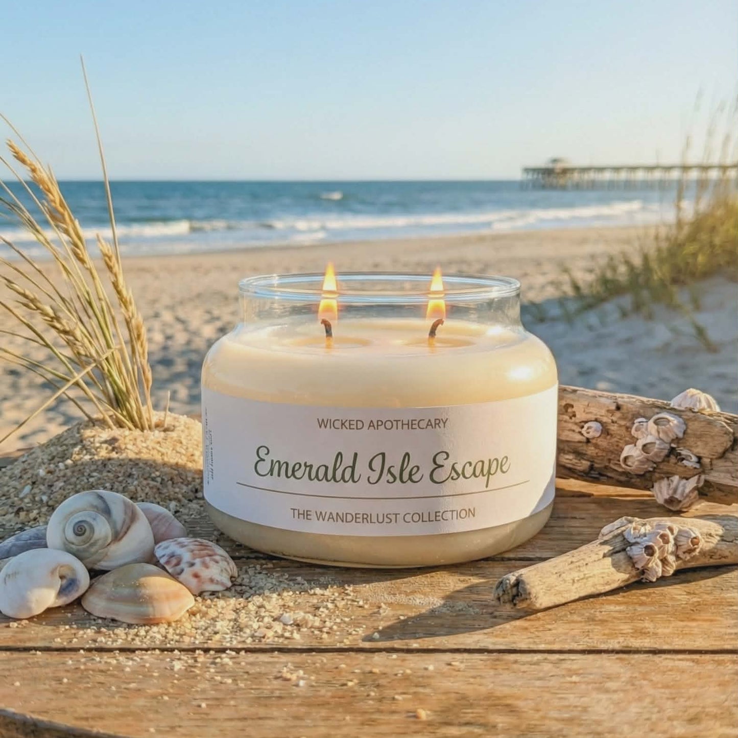 Candle labeled 'Emerald Isle Escape' on a wooden surface with a beach background