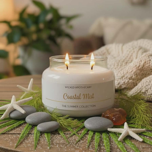Wicked Apothecary Coastal Mist candle on a decorative table with stones and starfish