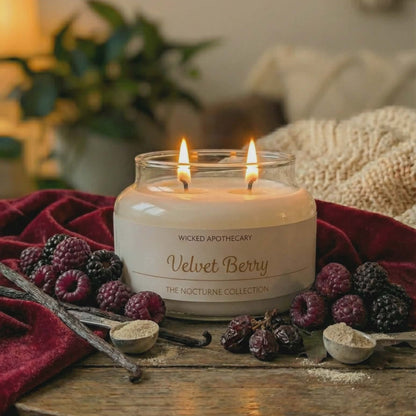 Wicked Apothecary Velvet Berry candle on a wooden table with berries and a cozy background
