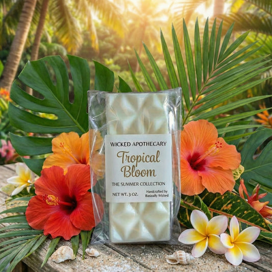 Wicked Apothecary Tropical Bloom candle packaging with tropical flowers and leaves in the background