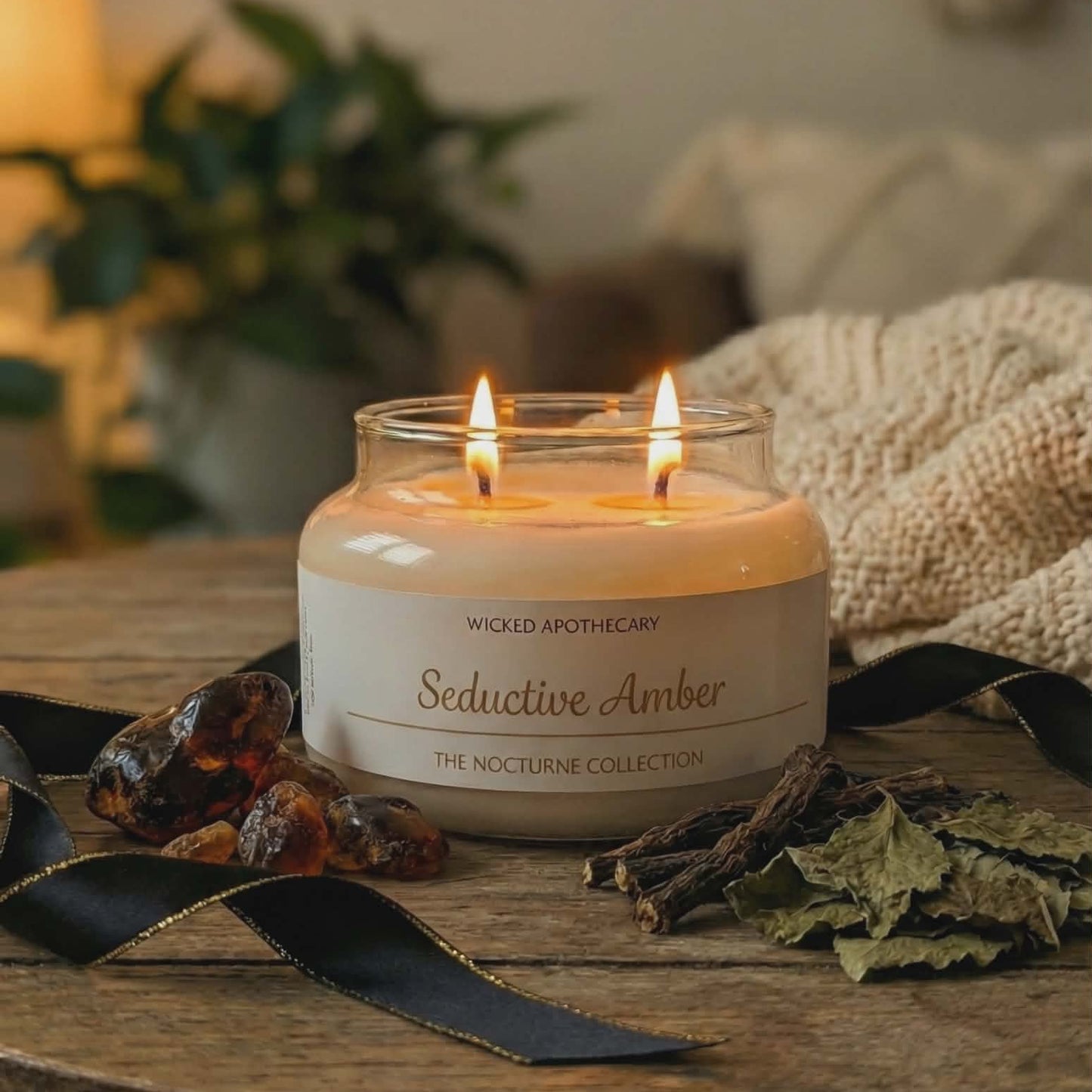Candle in a glass jar labeled 'Seductive Amber' on a wooden surface with decorative elements.