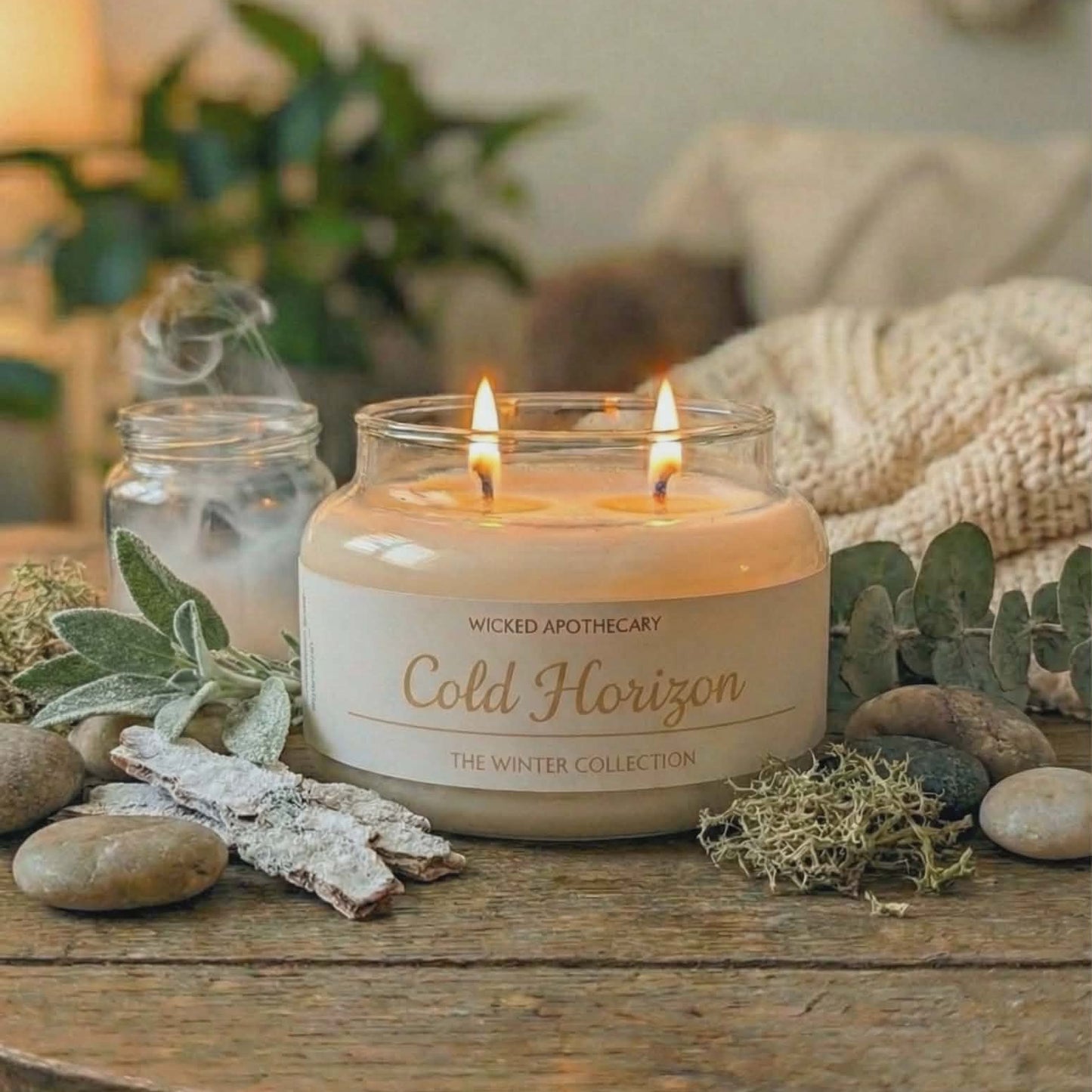 Candle labeled 'Cold Horizon' from Wicked Apothecary on a wooden surface with decorative elements.