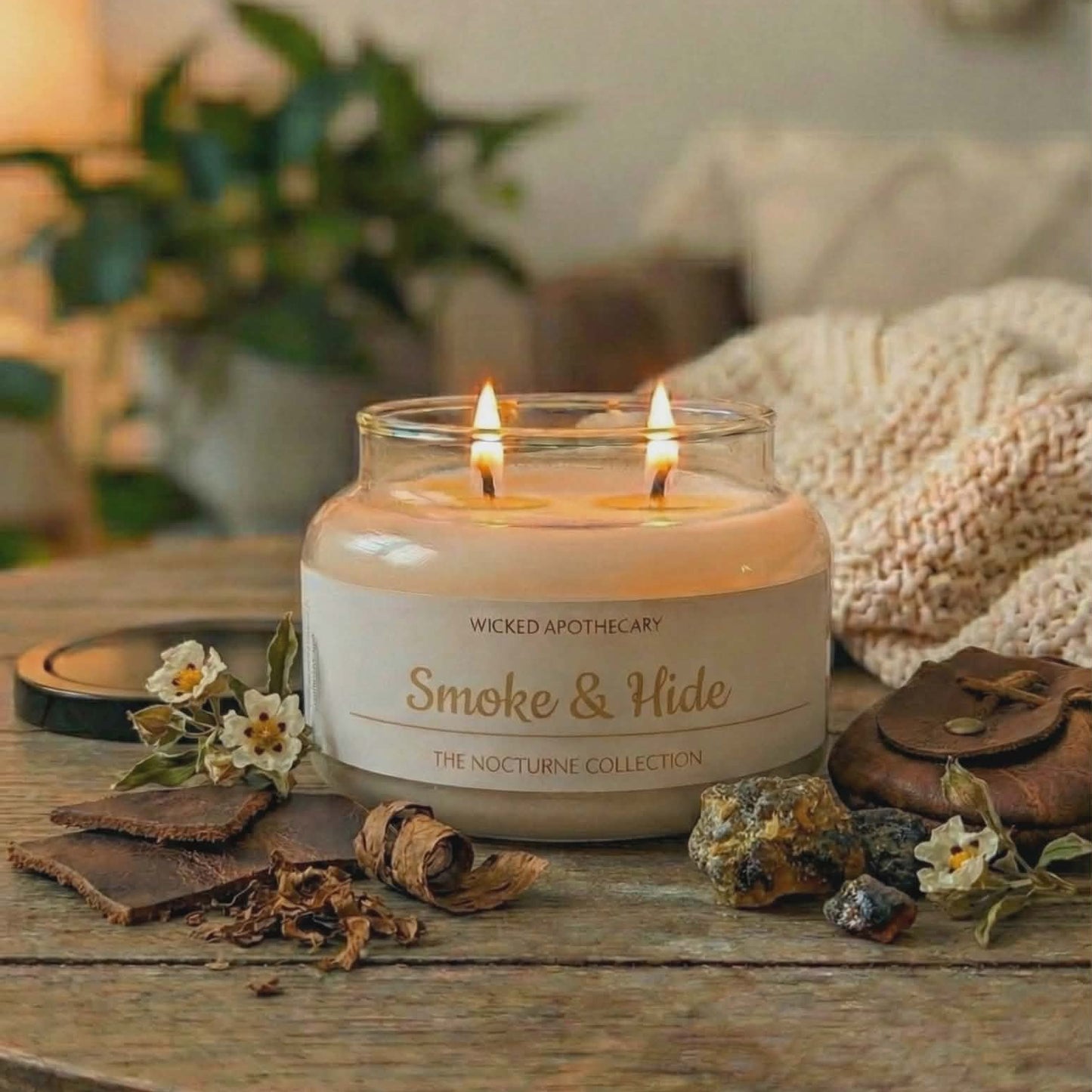 Candle labeled 'Smoke & Hide' on a wooden surface with decorative elements.
