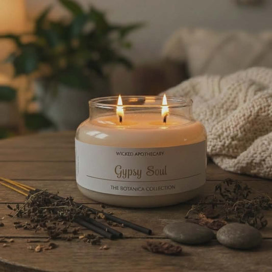 Candle labeled 'Gypsy Soul' from Wicked Apothecary on a wooden surface with decorative elements.