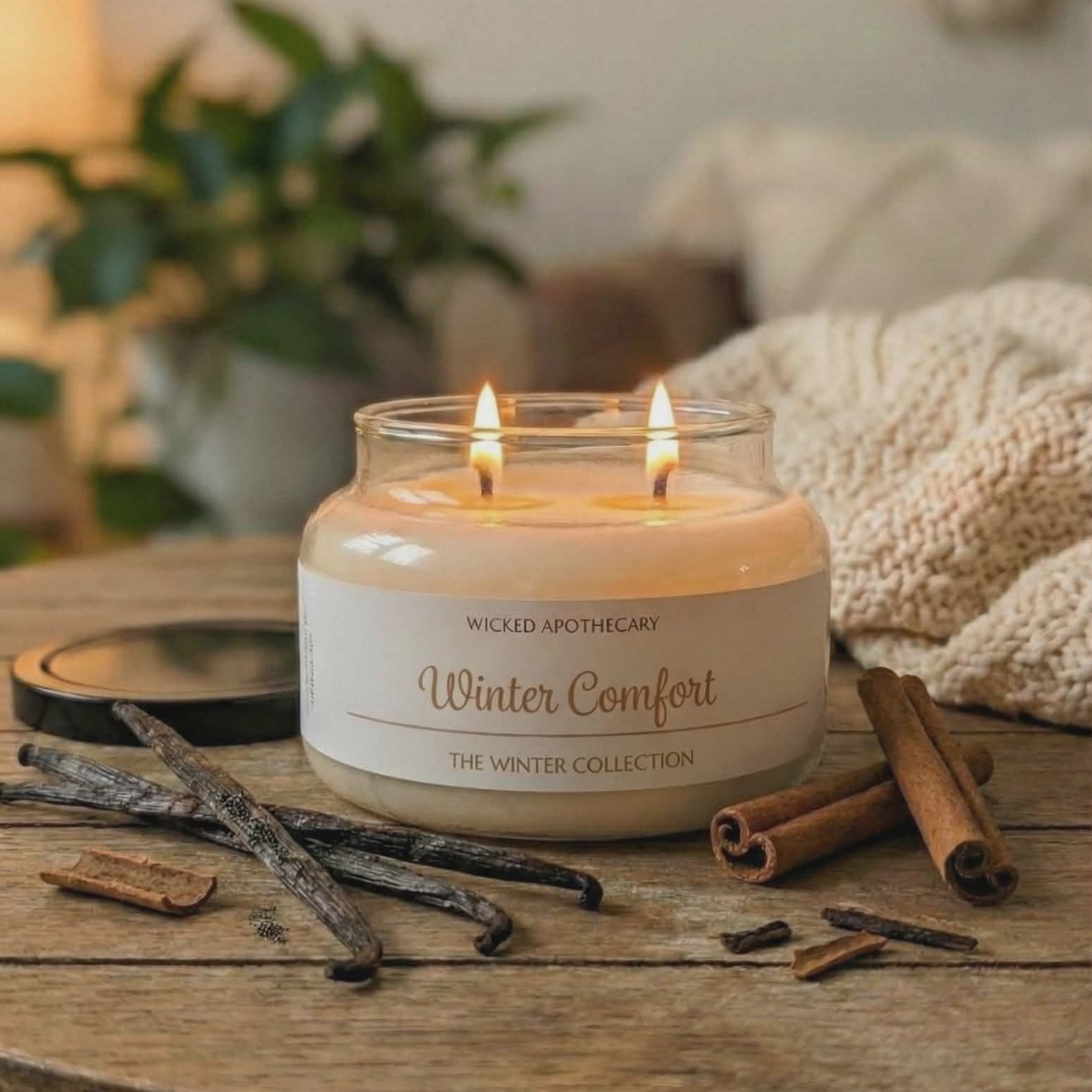 Candle labeled 'Winter Comfort' on a wooden table with cinnamon sticks and vanilla beans.