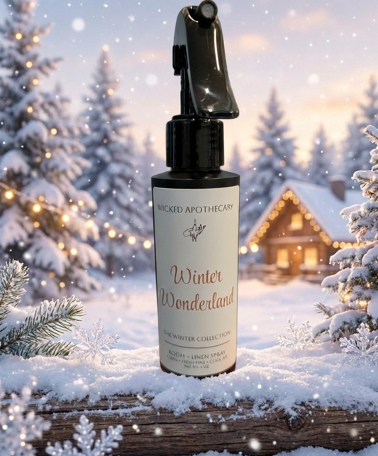 Spray bottle labeled 'Winter Wonderland' by Wicked Apothecary on a snowy background with Christmas trees and a cabin.